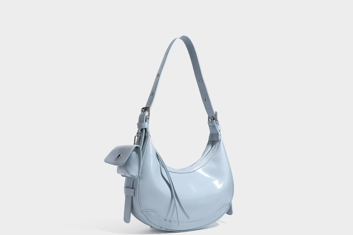 Glossy leather-look crescent hobo shoulder bag with dark contrast trim, silver-tone hardware, and attached mini flap pouch