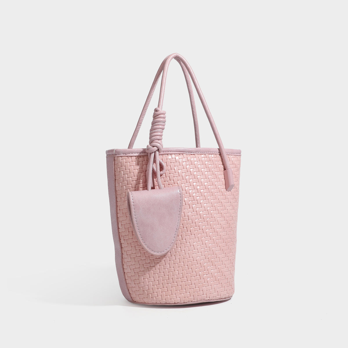 Structured woven-texture leather-look bucket bag in brown with knotted top handles, small front flap pouch, and adjustable