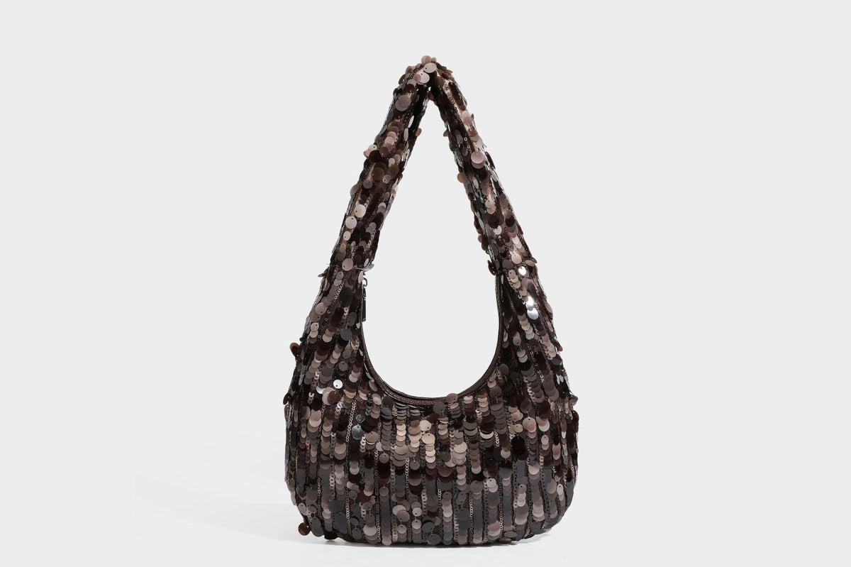 Slouchy crescent hobo shoulder bag covered in overlapping reflective sequin discs with a single integrated strap and top-zip