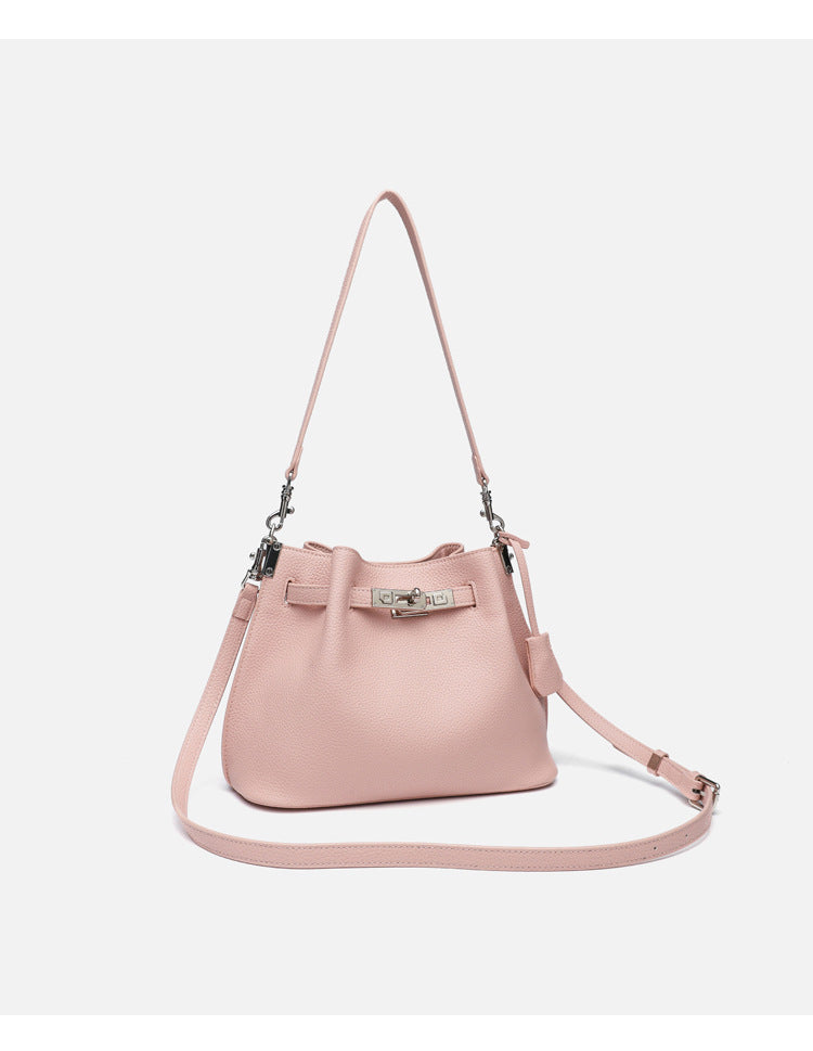 Soft-structured pebbled leather-look bucket bag with silver turn-lock front clasp and adjustable crossbody strap, detail view