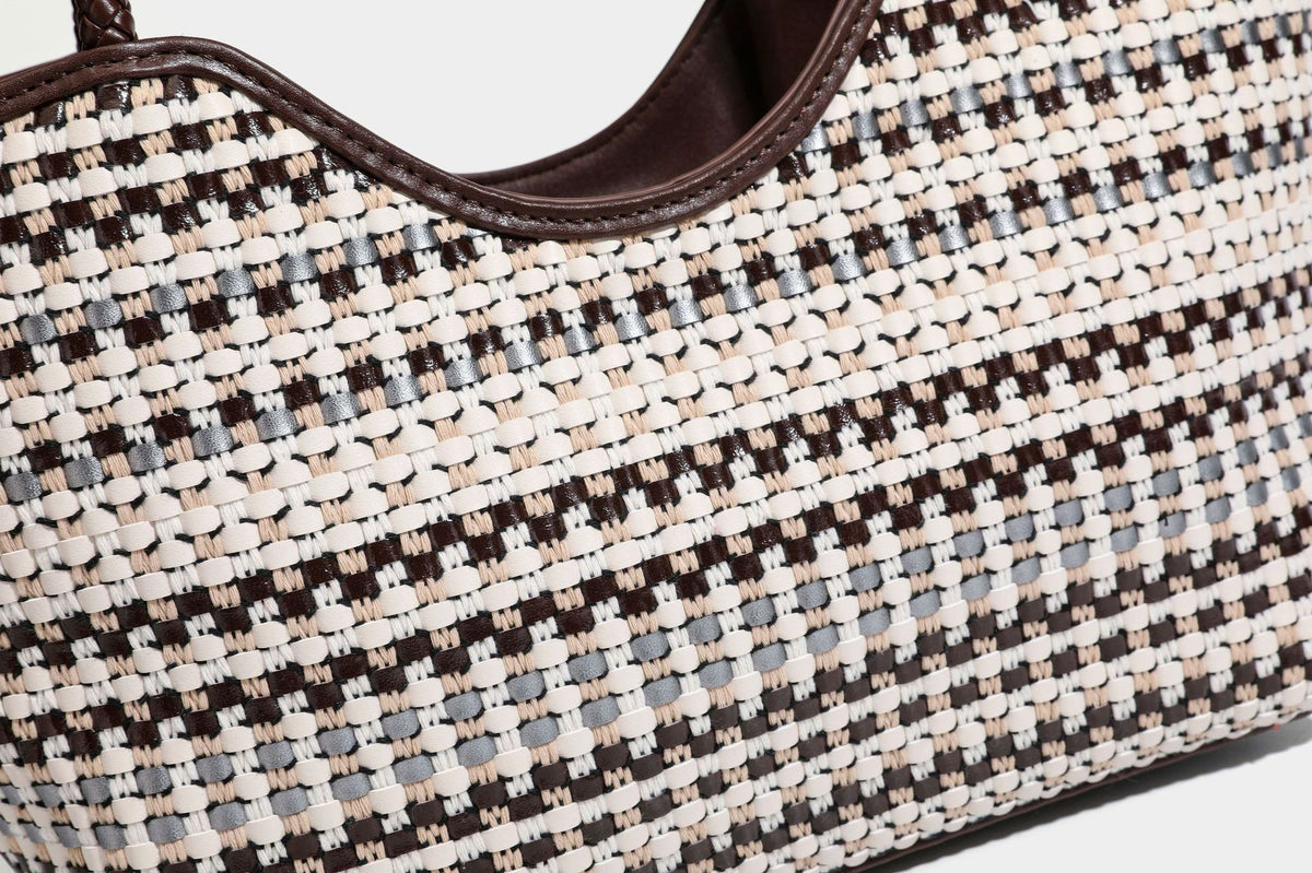 Large woven checker-pattern tote bag with dark braided shoulder straps, leather-look trim, and drawstring side ties, detail