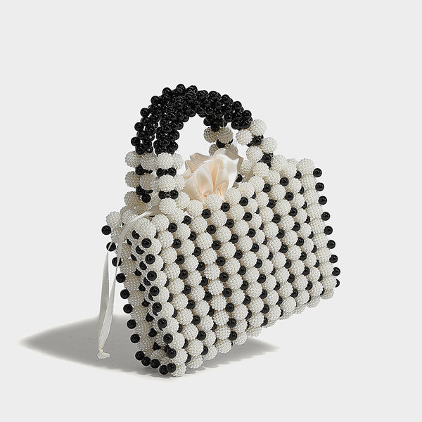 Small boxy pearl-bead mini top-handle bag with silver metallic bead accents, satin floral detail, and long beaded shoulder