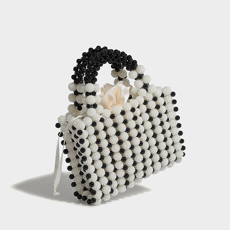 Small boxy pearl-bead mini top-handle bag with silver metallic bead accents, satin floral detail, and long beaded shoulder