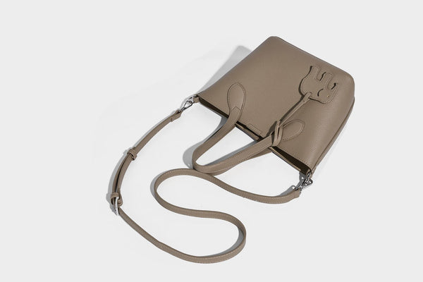 Compact pebbled bucket tote bag with elephant charm, twin top handles, and detachable crossbody strap, detail view 23