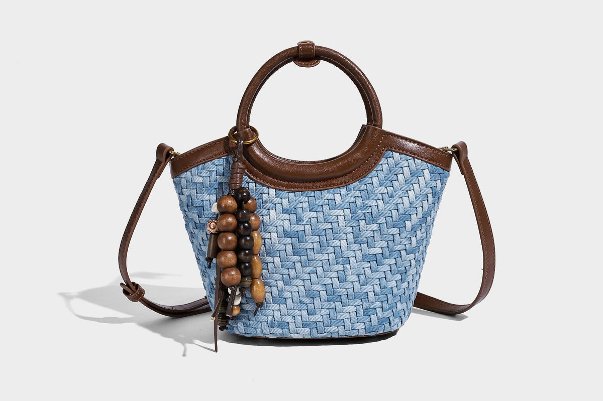Blaue gewebte Bucket-Bag in Denim-Optik mit Besatz in brauner Lederoptik, rundem Henkel, Quastenanhänger mit Holzperlen und verstellbarem