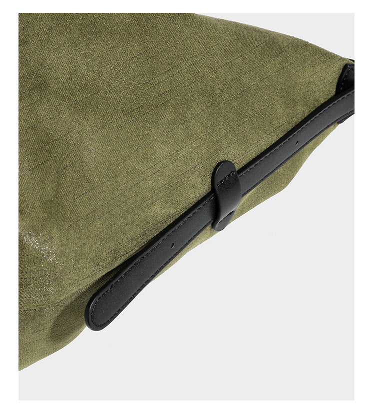 Slouchy olive green canvas hobo shoulder bag with black leather-look trim, zip-top closure, and adjustable strap, detail view