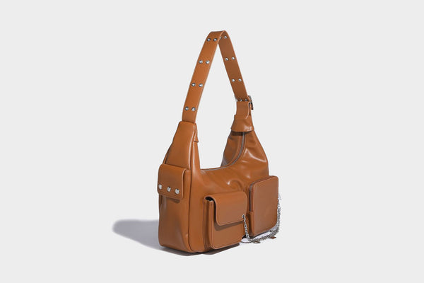 Lässig fallende Hobo-Schultertasche mit glänzender Lederoptik, vorderen Klappentaschen, Kettenapplikationen und silberfarbenen Nietbeschlägen