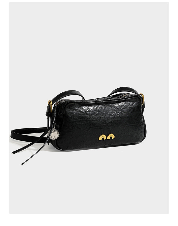 Compact black crinkled leather-look baguette shoulder bag with gold-tone arch hardware and adjustable strap, detail view 7