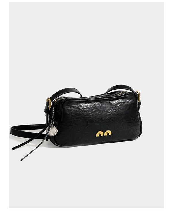 Compact black crinkled leather-look baguette shoulder bag with gold-tone arch hardware and adjustable strap, detail view 7