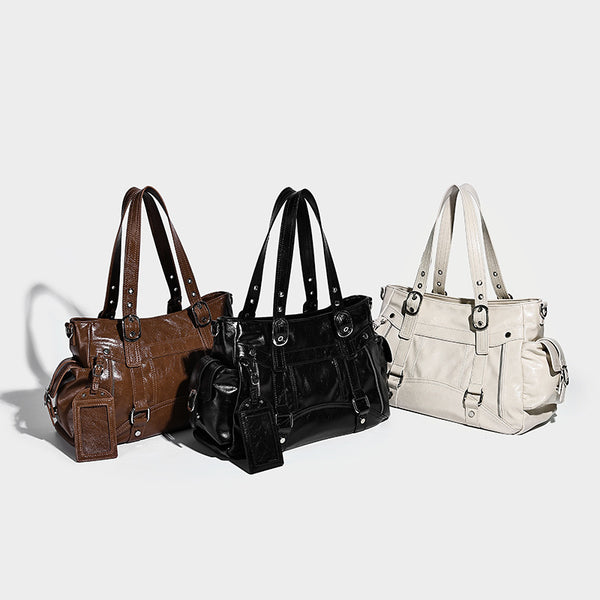 Glossy structured black tote shoulder bag with silver buckle hardware, zip pockets, dual top handles, and detachable, detail