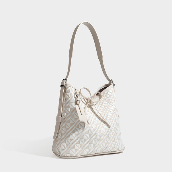 Woven geometric bucket shoulder bag in white and dark brown two-tone pattern with leather-look trim and drawstring top