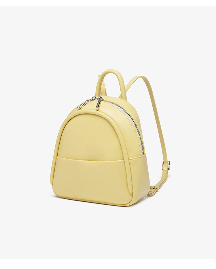 Kleine kuppelförmige Mini-Rucksackhandtasche in Pastellgelb mit glatter Lederoptik, oberem Bogenreißverschluss und silberfarbenen Details, Detailansicht