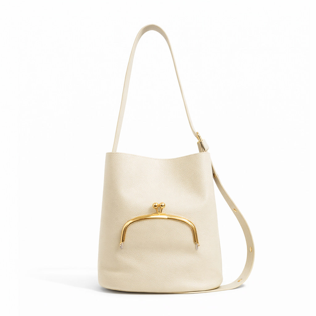 Pebbled textured bucket bag with gold-tone kiss-lock front pocket and adjustable single shoulder strap, detail view 2