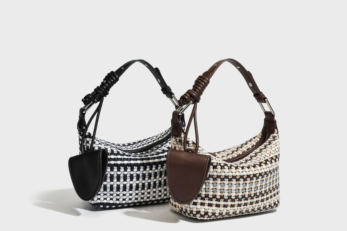 Small crescent shoulder bag in black-and-white woven textile with smooth black leather-look trim, zip-top closure, knotted