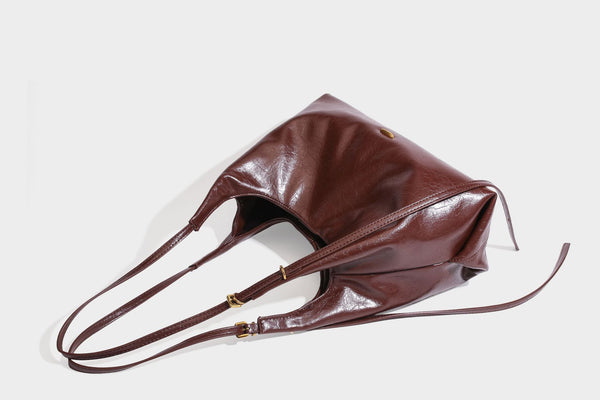 Locker fallende Hobo-Schultertasche mit offenem Oberteil aus glänzendem, geknautschtem Lederimitat in Dunkelbraun, mit schmalem verstellbarem Riemen und goldfarbenem