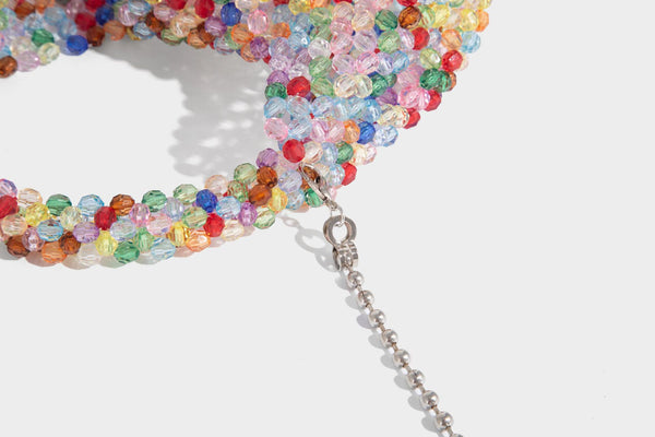 Kleine, abgerundete Hobo-Bag mit facettierten, durchscheinenden Perlen in Kristalloptik, passendem Perlenhenkel oben und silberfarbenen Details