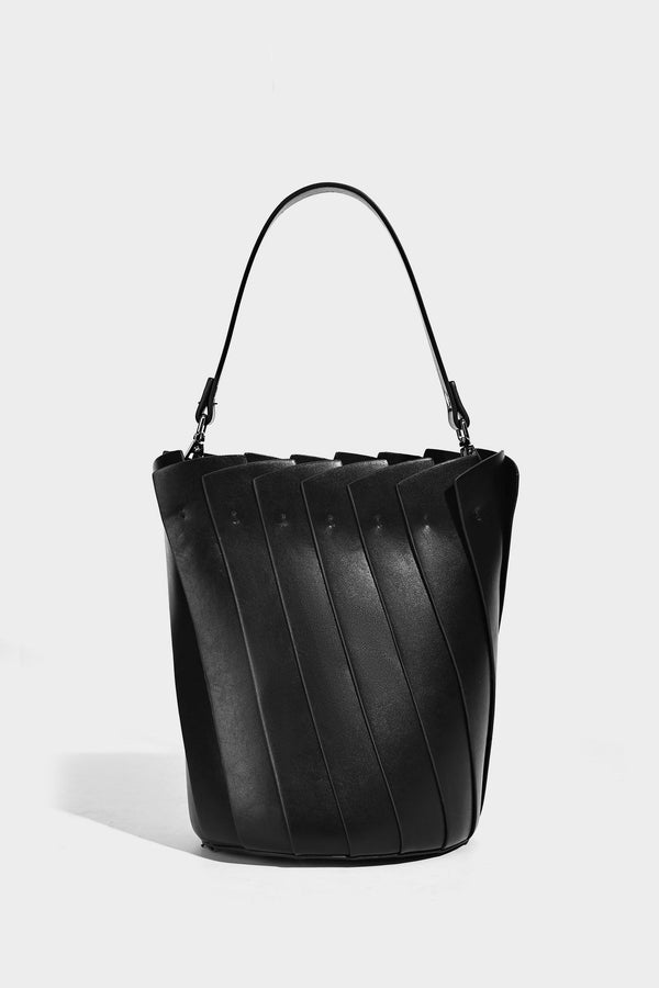 Structured pleated-panel bucket bag with curved top handle and detachable adjustable shoulder strap in smooth matte, detail