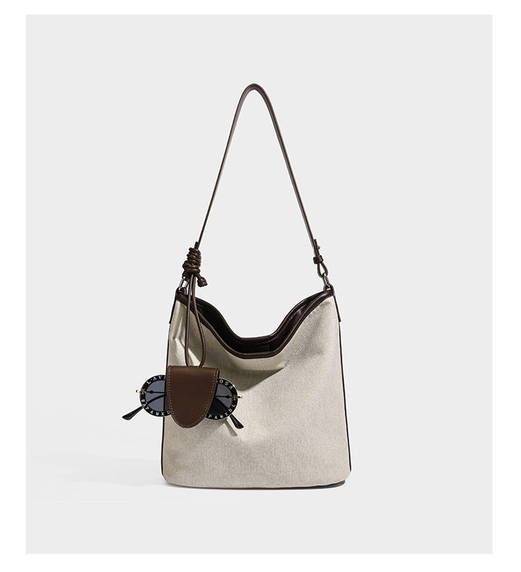 Cremefarbene Canvas-Schultertasche im Beuteltaschen-Stil mit dunkelbraunen Details in Lederoptik, geknotetem Riemen und befestigtem Mini-Etui, Detailansicht 9