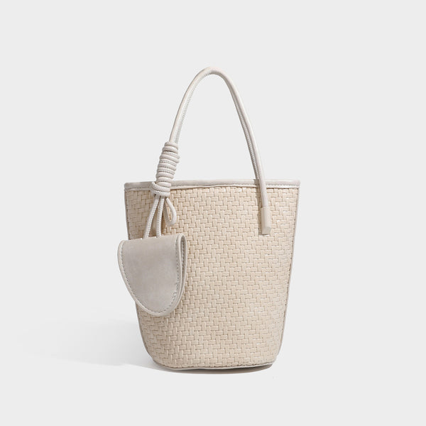 Structured woven-texture leather-look bucket bag in brown with knotted top handles, small front flap pouch, and adjustable