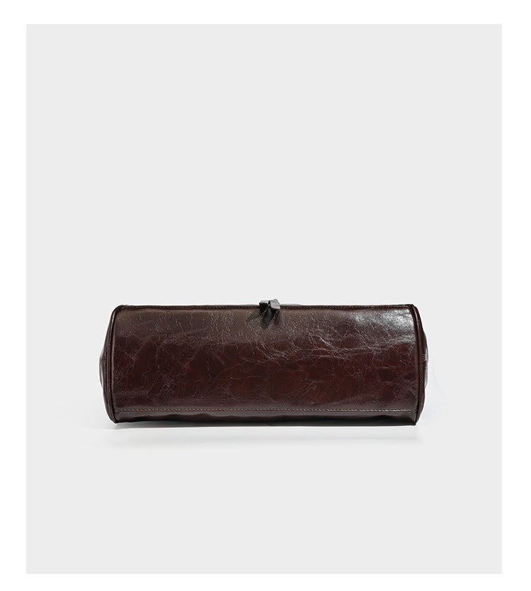 Dark brown glossy leather-look structured satchel tote with gold-tone studs, buckle straps, dual top handles, and detachable