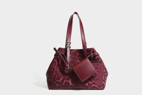 Glossy leopard-print tote bag with leather-look dark trim, dual top handles, detachable shoulder strap, and attached front