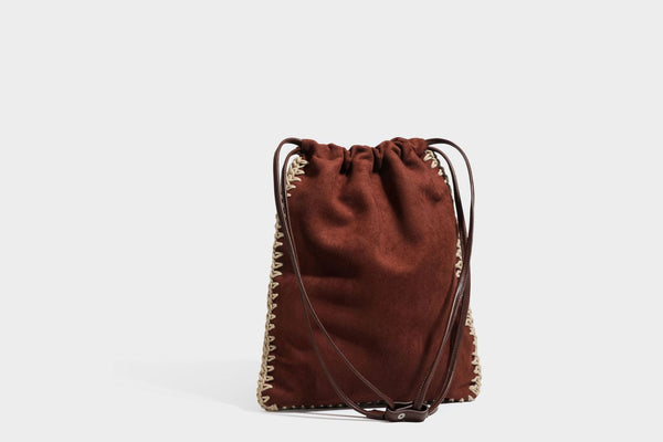 Matte suede-look drawstring bucket bag with cream braided woven edge trim and slim adjustable leather-look shoulder strap