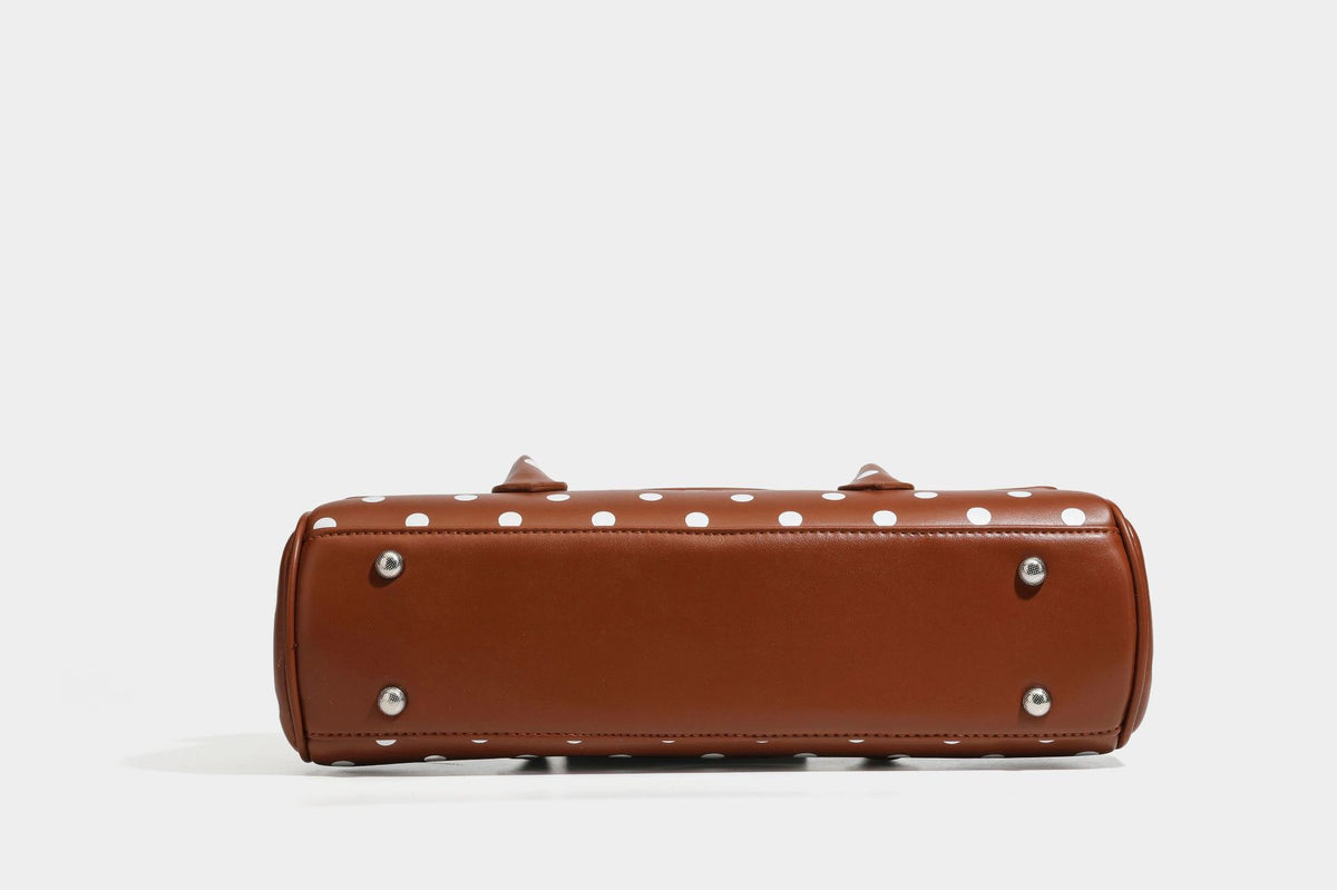 Strukturierte Baguette-Tasche mit Punktemuster in glänzender Lederoptik, zwei Tragegriffen, Überschlag mit Drehverschluss in Silberoptik und