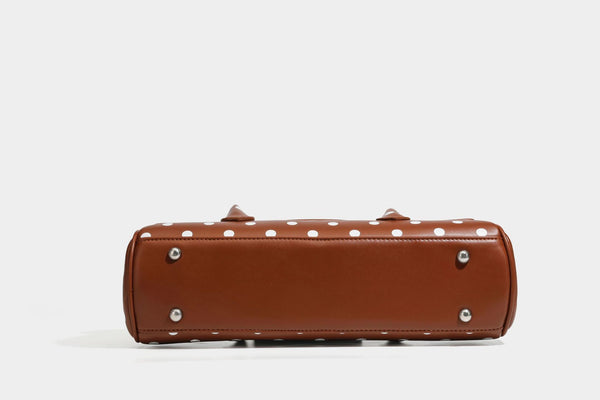 Strukturierte Baguette-Tasche mit Punktemuster in glänzender Lederoptik, zwei Tragegriffen, Überschlag mit Drehverschluss in Silberoptik und