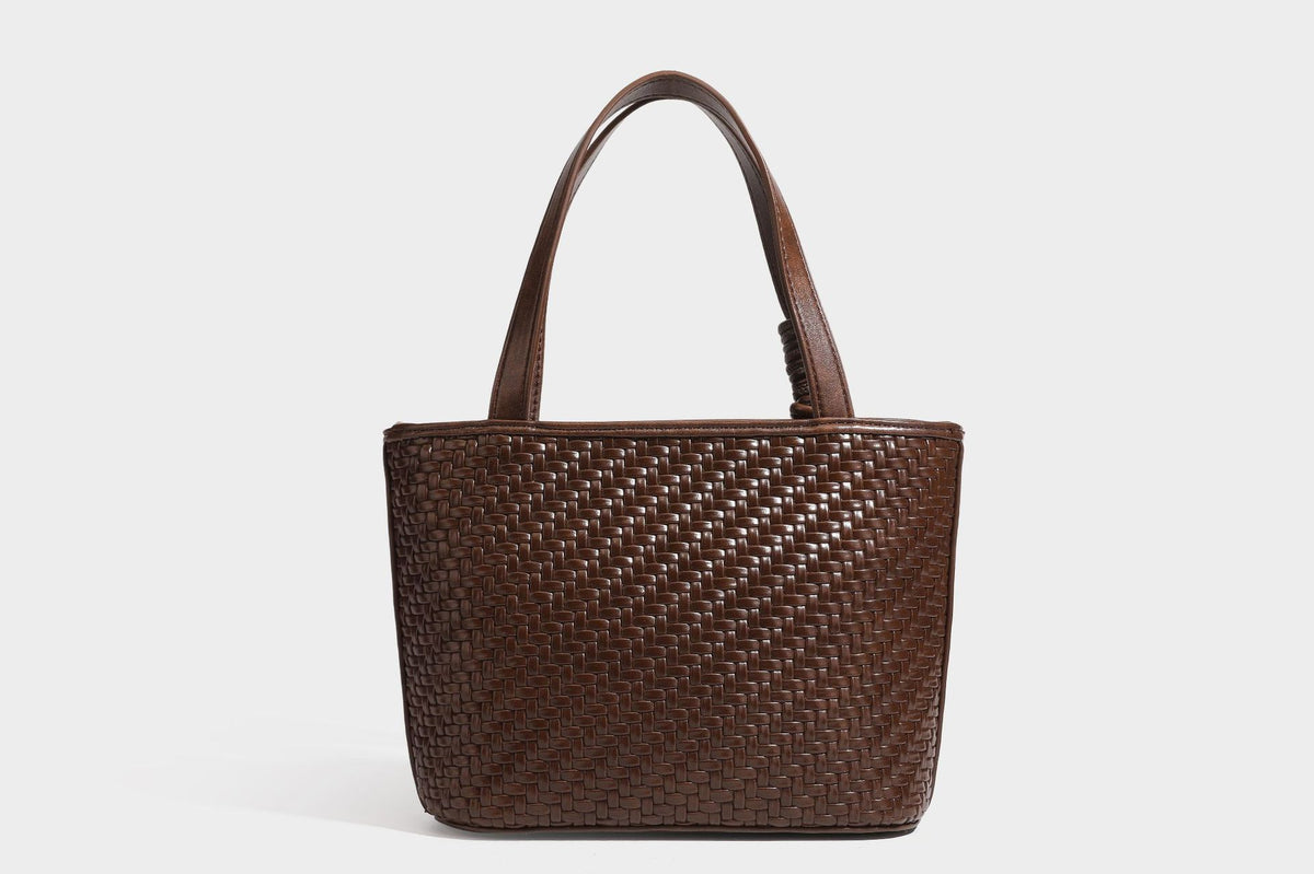 Strukturierte Tote Bag mit gewebter Oberfläche in Braun, goldfarbenen Metalldetails, seilumwickelten Tragegriffen, einer kleinen Fronttasche und weiteren Details
