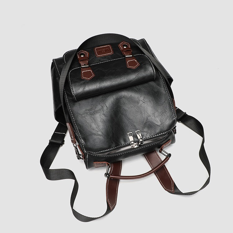 Structured black leather-look convertible backpack handbag with brown contrast trim, buckle front pocket, double-zip top