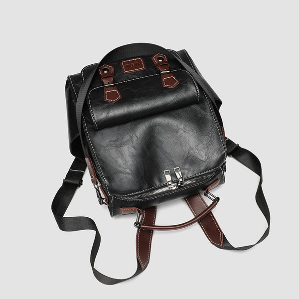 Structured black leather-look convertible backpack handbag with brown contrast trim, buckle front pocket, double-zip top