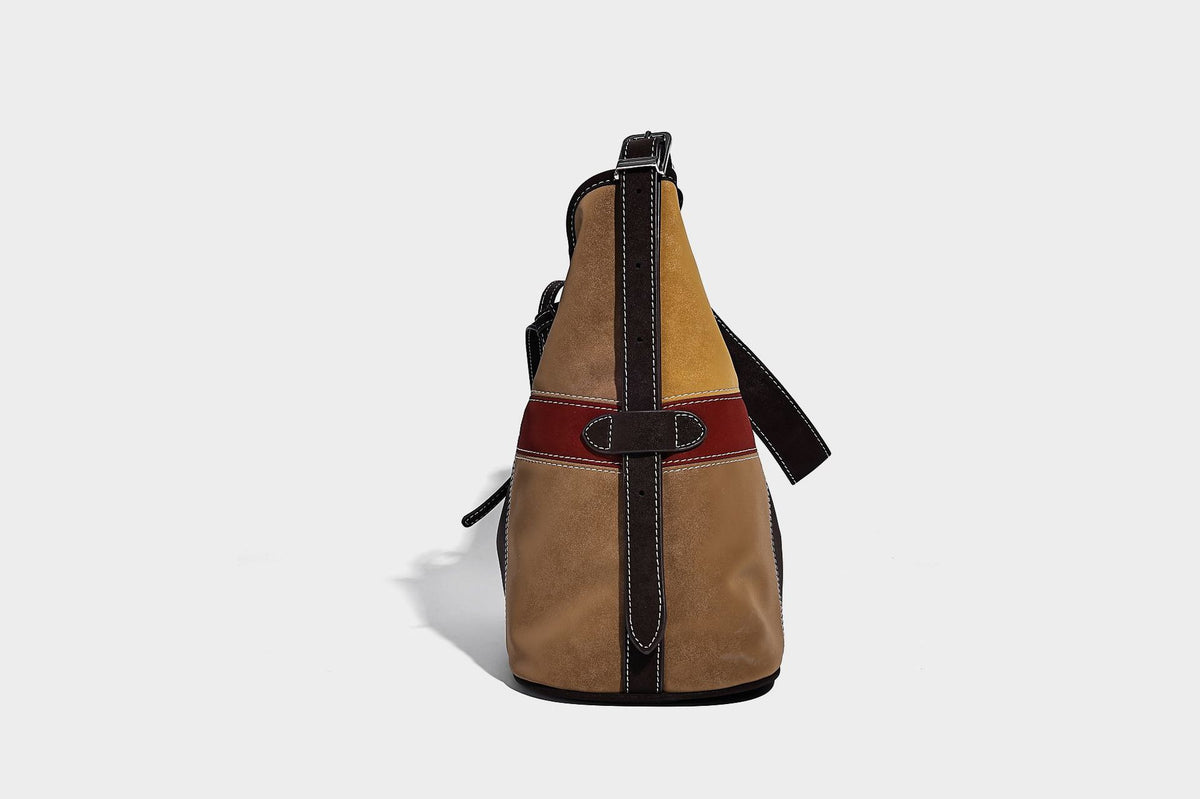 Patchwork bucket tote shoulder bag with tan, dark brown, olive, red, and sky blue color-block panels, white contrast, detail