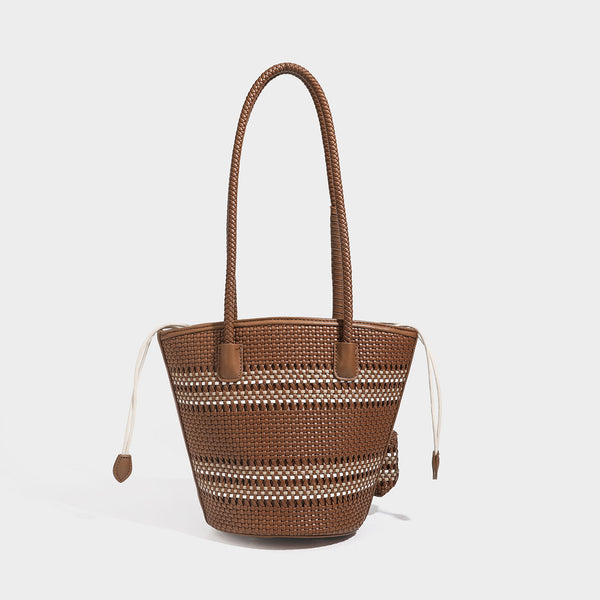 Light blue open-weave woven bucket tote bag with long braided shoulder straps, drawstring side ties, and attached mini pouch