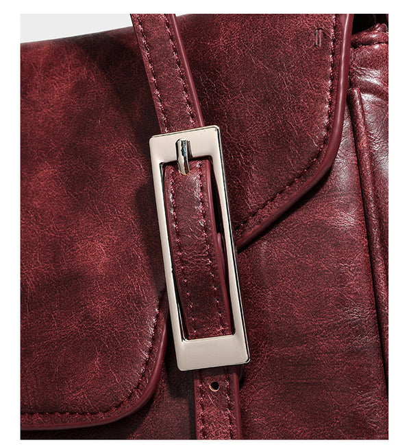 Large structured shoulder tote bag in wine red textured leather-look finish with front flap closure and silver-tone buckle