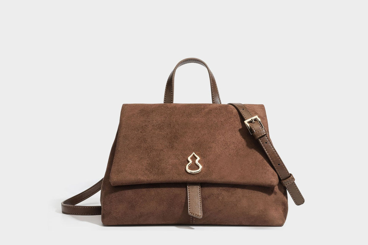 Formstabile Satchel-Tasche mit mattem Veloursleder-Finish, Überschlag, goldfarbenen Emblem-Beschlägen, kurzem Tragegriff und verstellbarem Crossbody-Riemen