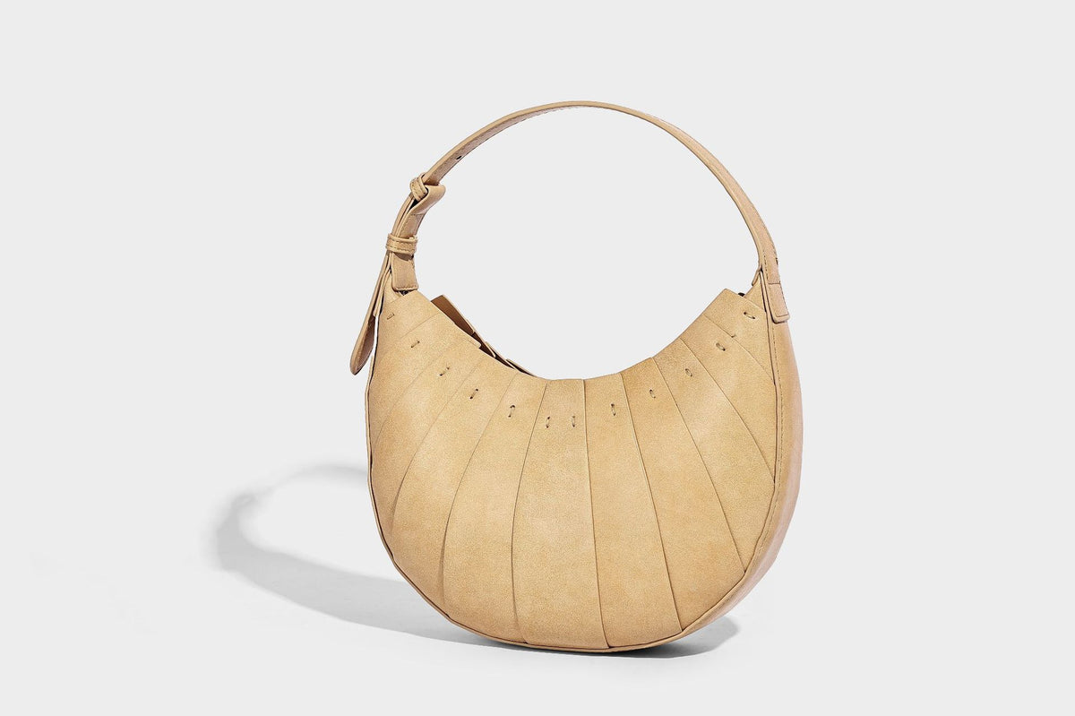 Crescent half-moon shoulder bag with vertical panel seaming, matte-satin leather-look finish, and adjustable gold-tone