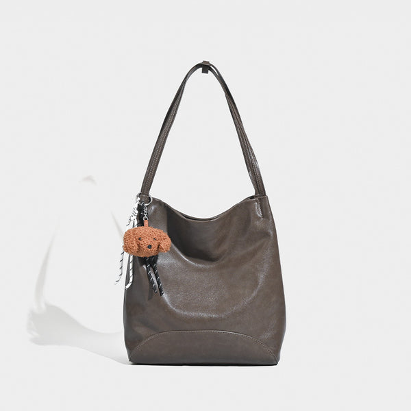 Slouchy leather-look shoulder tote with bear charm tassel in black and coffee brown, detail view 7