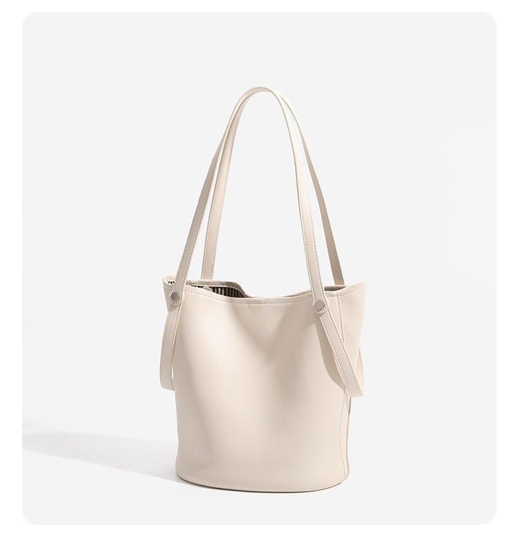 Large leather-look bucket tote bag with dual top handles and adjustable crossbody strap, detail view 11