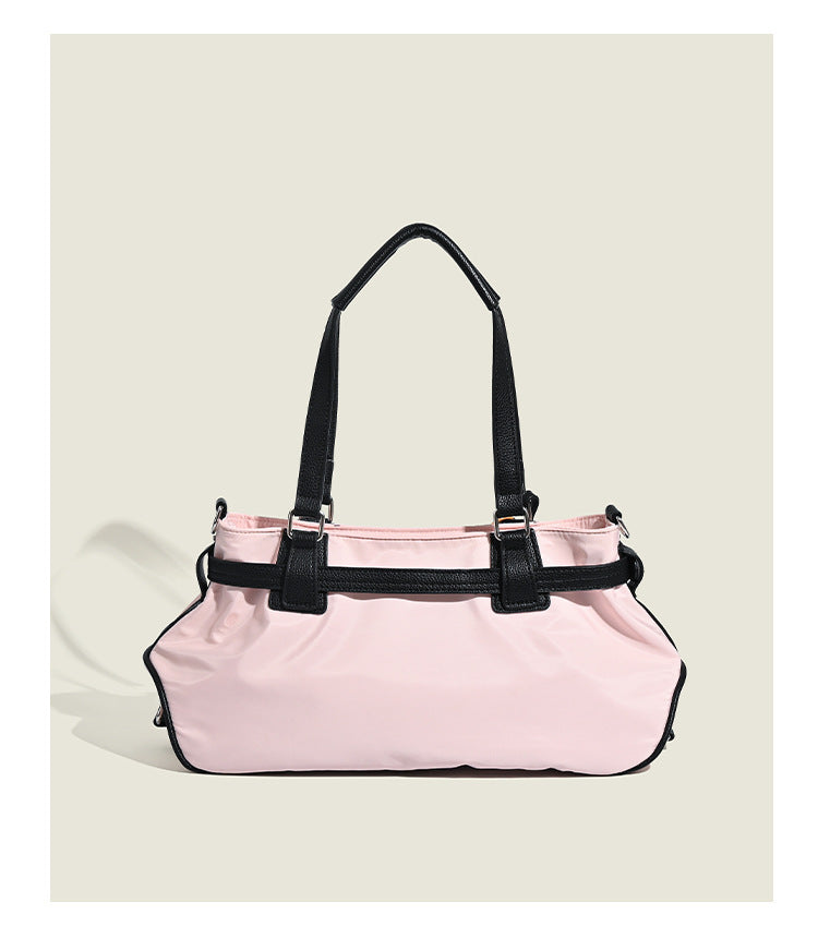 Pale pink nylon tote bag with black leather-look trim, double top handles, side zip pocket, and detachable crossbody strap