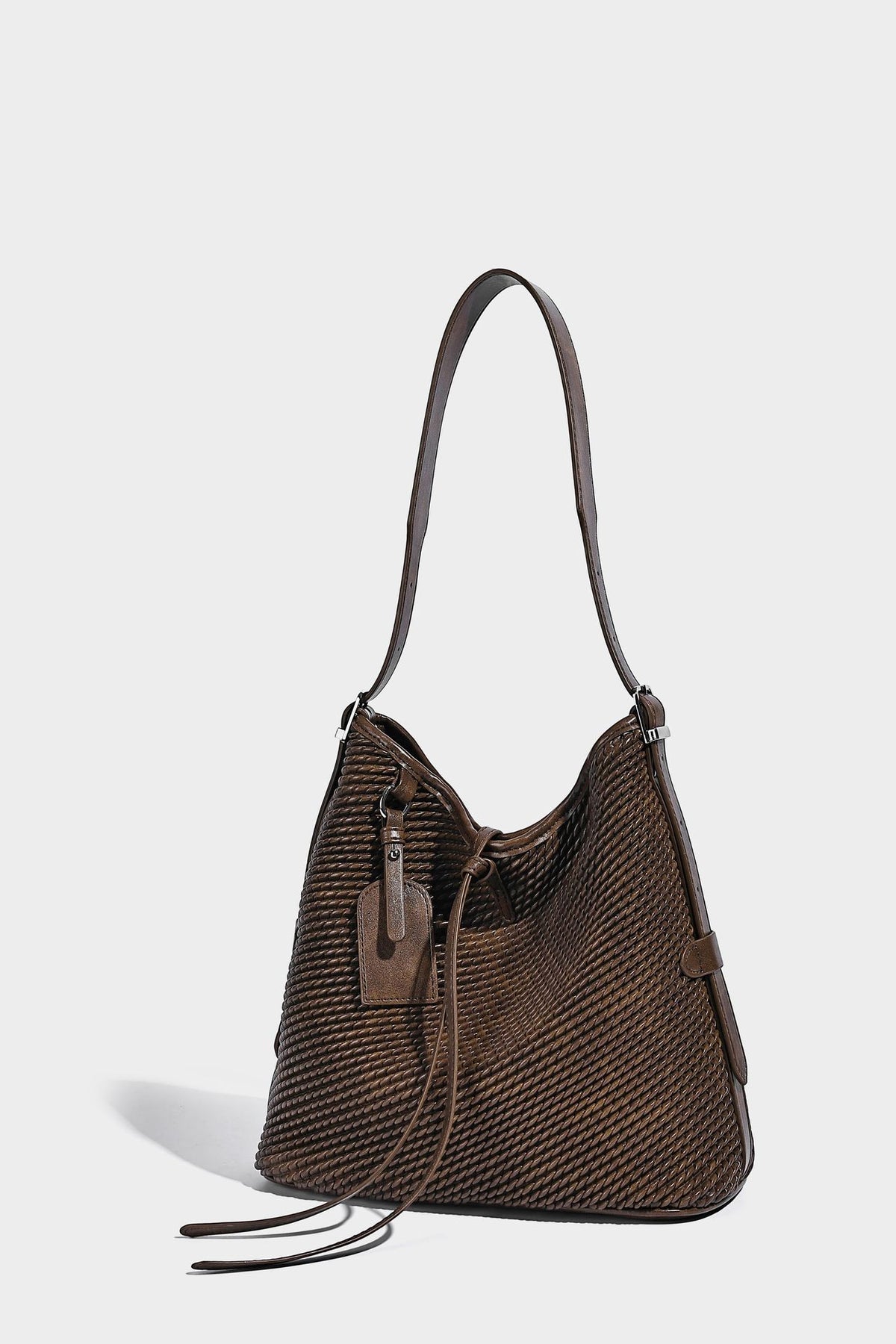 Große Schultertasche in Beutelform mit Flechtoptik, glatten Besätzen in Lederoptik, verstellbarem Riemen und hängendem Anhänger-Detail, Detailansicht