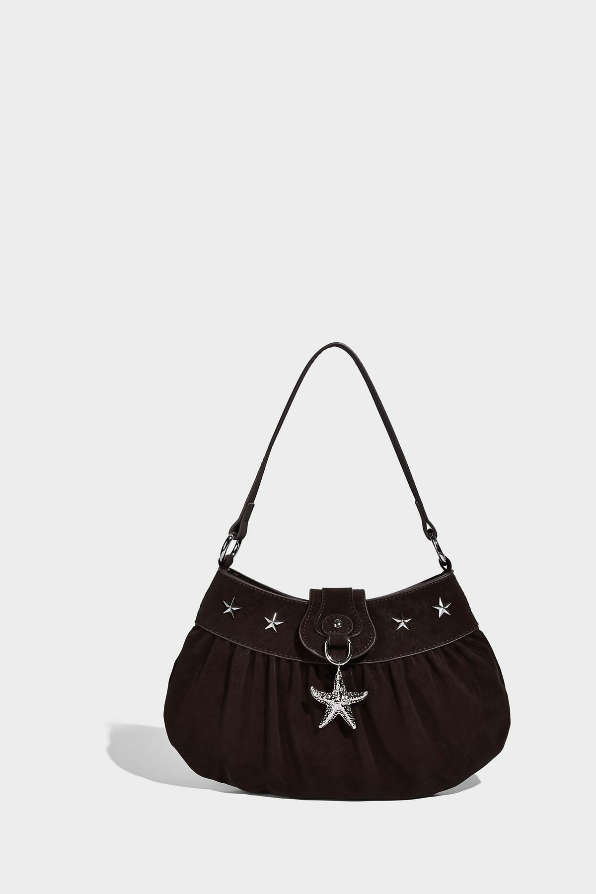 Ruched shoulder bag with curved flap, silver star studs, dangling starfish charm, and adjustable crossbody strap, detail view