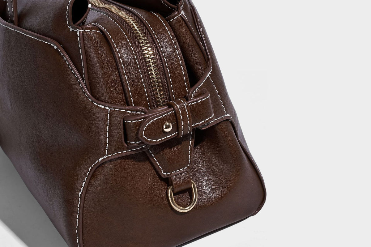 Strukturierte rechteckige Baguette-Schultertasche aus dunkelbraunem Material in glatter Lederoptik mit zwei Riemen und Reißverschluss oben