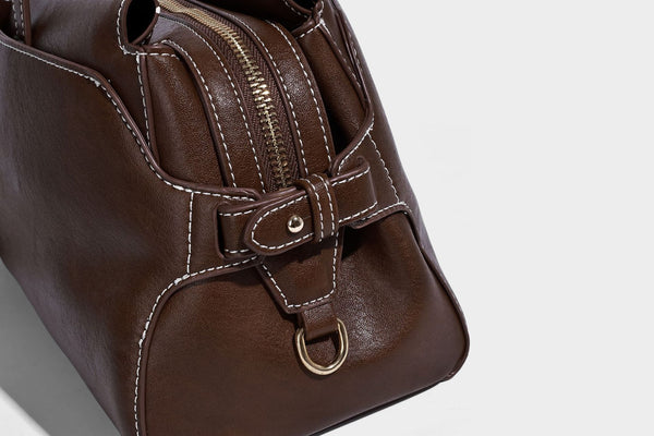 Strukturierte rechteckige Baguette-Schultertasche aus dunkelbraunem Material in glatter Lederoptik mit zwei Riemen und Reißverschluss oben