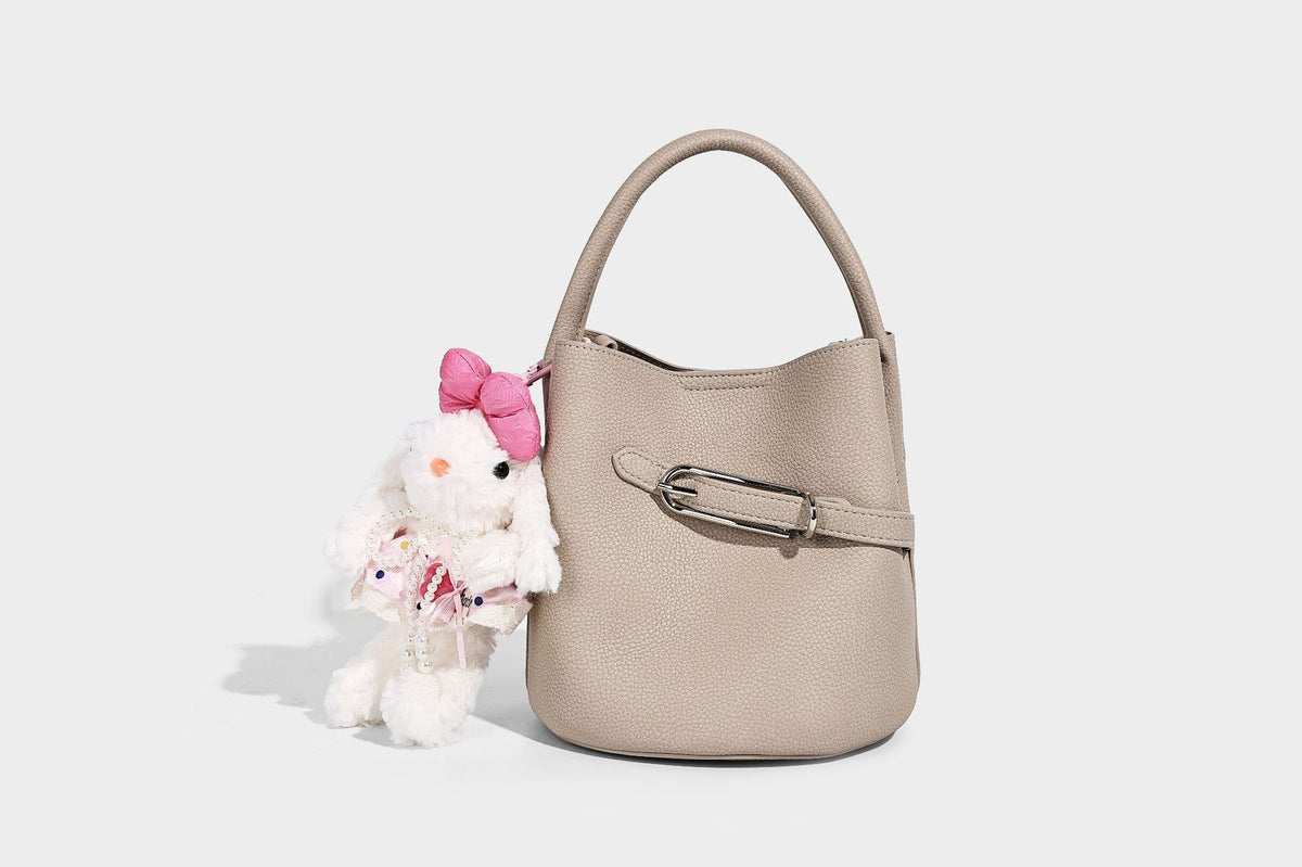 Mini pebbled leather-look bucket bag with front buckle strap, silver-tone hardware, top handle, and detachable shoulder