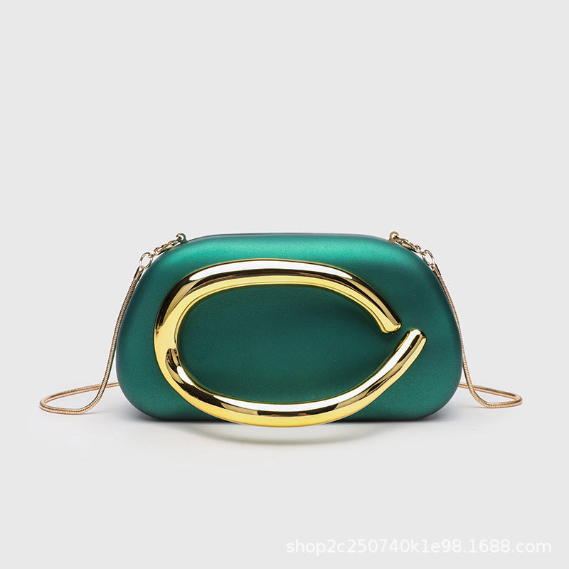 Kleine rechteckige Crossbody-Clutch mit abgerundeten Ecken, oversized poliertem C-förmigem Goldgriff und schmalem Goldkettenriemen, Detailansicht