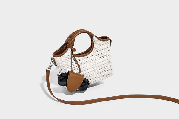 Small structured woven tote crossbody bag with ring top handle, leather-look brown trim, front patch pocket, and detachable