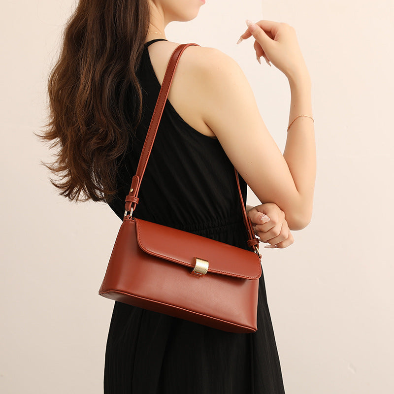 Structured flap crossbody shoulder bag in cognac red leather-look finish with gold-tone cylindrical turn-lock closure and