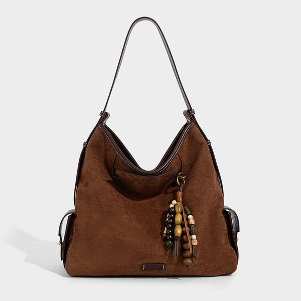 Weich fallende Hobo-Schultertasche in Khaki mit matter Velourslederoptik, Besatz in dunkelbrauner Lederoptik, Quastenanhänger mit Perlen und seitlicher Klappe, Detailansicht