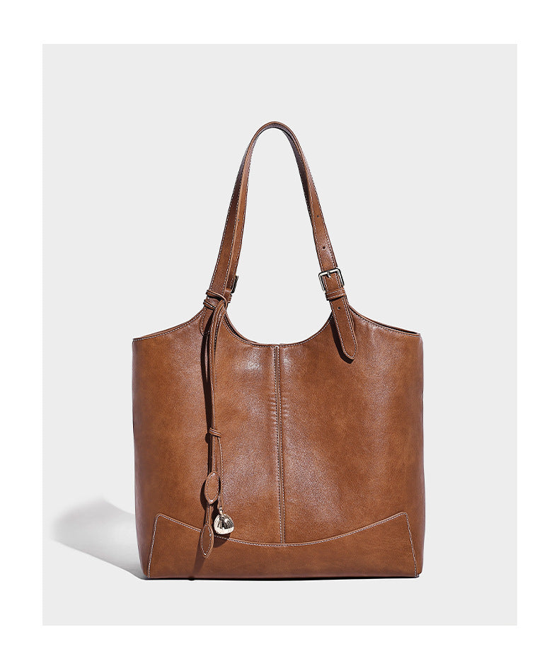 Große, strukturierte Schultertasche im Tote-Stil in Braun und Lederoptik mit langen Doppelriemen, Schnallenbeschlägen, Quasten-Anhänger und geschwungener