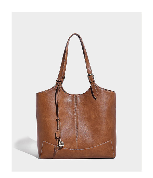 Große, strukturierte Schultertasche im Tote-Stil in Braun und Lederoptik mit langen Doppelriemen, Schnallenbeschlägen, Quasten-Anhänger und geschwungener